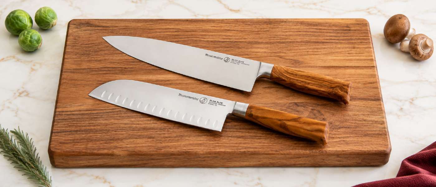 The Messermeister Oliva Elite Chef Knife and Santoku Knife on a cutting board