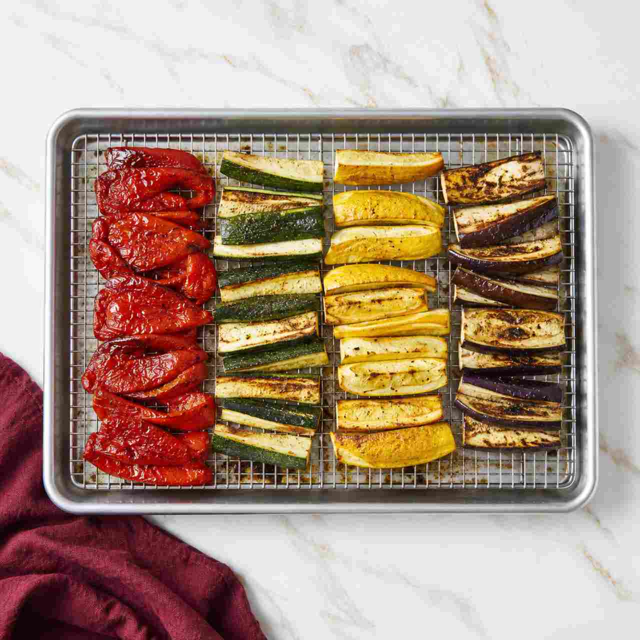 An overhead view of a cooling rack and sheet pan with a roasted vegetable rainbow