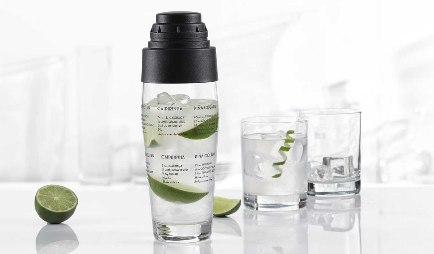 A glass cobbler shaker with two cocktails
